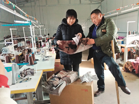 在瑞浩扶残助困加工厂服装车间里，吕文书（右）正在和工人研究新的服装样式。_副本.jpg